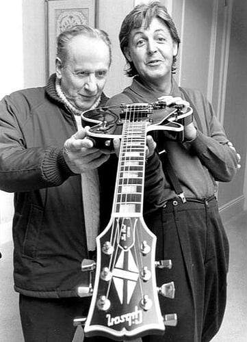 Les Paul with Paul McCartney holding McCartney's Les Paul in 1988
